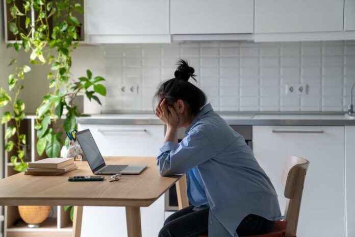 Unhappy,Frustrated,Young,Woman,Sitting,At,Kitchen,Table,Looking,At
