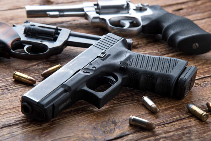 Gun,With,Ammunition,On,Wooden,Background.