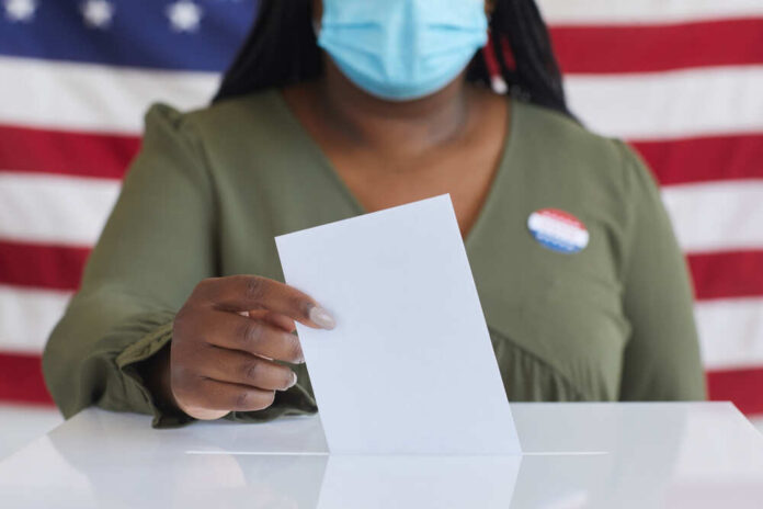 Close,Up,Of,African-american,Woman,Wearing,Mask,Putting,Vote,Bulletin
