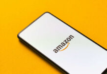 Smartphone displaying Amazon logo on yellow background