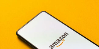 Smartphone displaying Amazon logo on yellow background