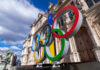 Olympic rings statue near historical building in Paris