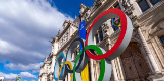 Olympic rings statue near historical building in Paris