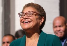 Mayor’s Pothole Stunt Explodes on Live TV A woman with glasses smiling joyfully at an outdoor event