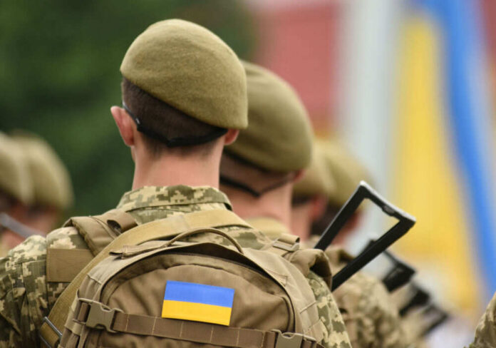 Soldiers in uniform with Ukrainian flag patches.