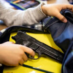 Person places handgun into a backpack