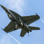 Jet flying in cloudy blue sky overhead view