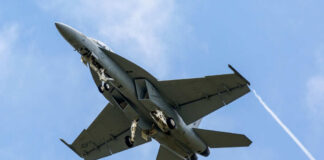 Jet flying in cloudy blue sky overhead view