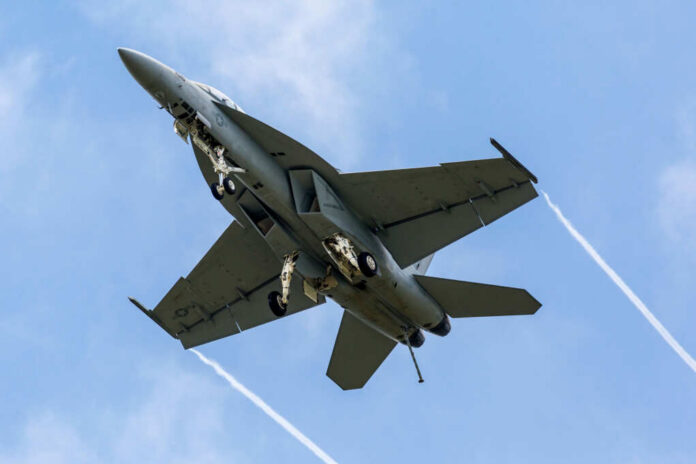Jet flying in cloudy blue sky overhead view