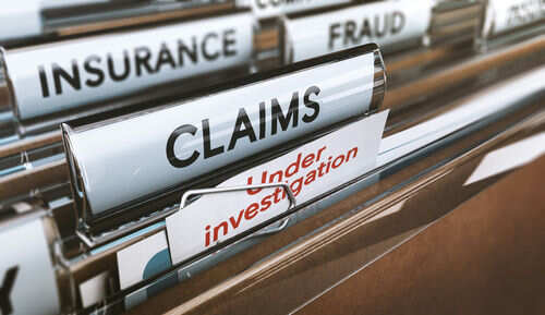 File folders labeled insurance, fraud, claims, investigation.