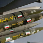 Camouflaged missiles with flag decals mounted on display.