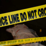 Police tape and covered figure at crime scene