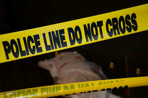 Police tape and covered figure at crime scene