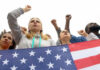 People raising fists with American flag nearby.