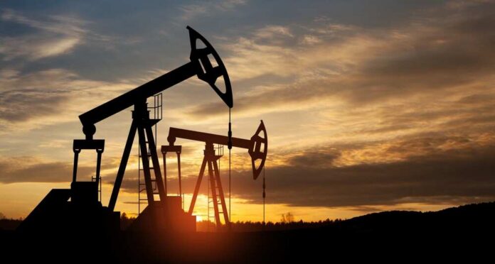 Silhouetted oil pumps against a colorful sunset sky