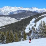 Teen’s Miraculous Survival After Vail Ski Horror A skier navigating down a snowy slope with mountains in the background