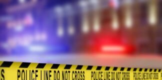 Yellow police caution tape with the text 'POLICE LINE DO NOT CROSS' in a blurred background