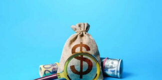 Money bag and magnifying glass on blue background