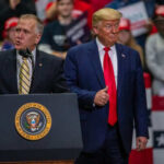Two men speaking at a political rally event