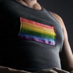 Person wearing shirt with rainbow flag patch