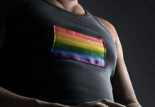 Person wearing shirt with rainbow flag patch