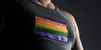 Person wearing shirt with rainbow flag patch