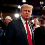 Man in suit with red tie at crowded event