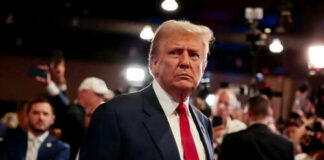 Man in suit with red tie at crowded event