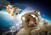 Astronaut and satellite orbiting Earth.