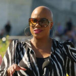 Person speaking outdoors wearing zebra print jacket