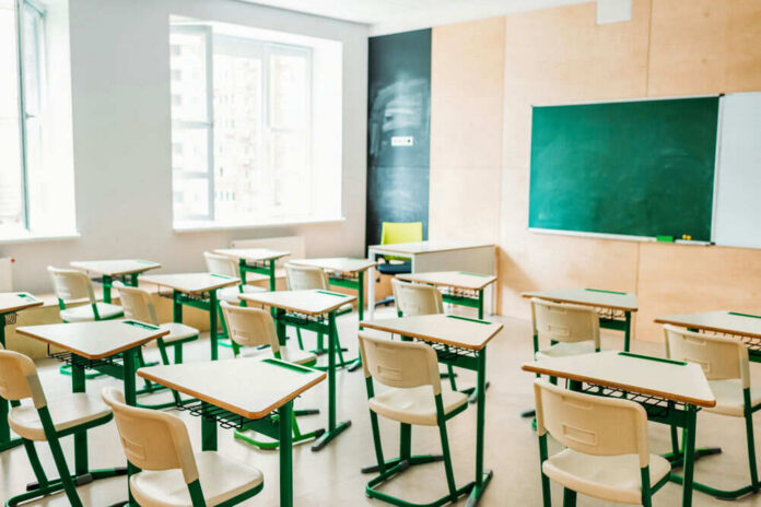 Empty classroom with desks facing a chalkboard