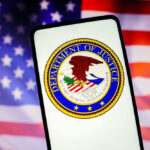 Department of Justice seal on phone, American flag background.