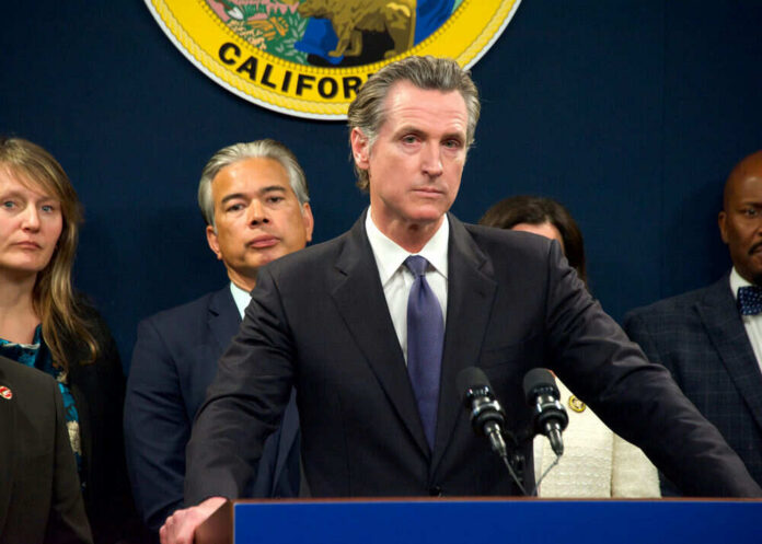 Person speaks at podium with California seal behind.