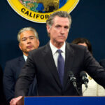 Person speaks at podium with California seal behind.