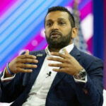 Person speaking on stage with colorful background