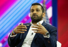 Person speaking on stage with colorful background