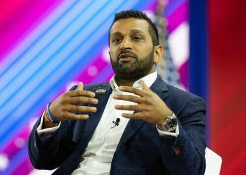 kash-patel2270821403 Person speaking on stage with colorful background