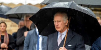 Man holding umbrella in rainy weather with crowd