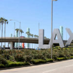 LAX sign with palm trees and blue sky