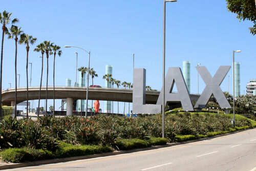 LAX sign with palm trees and blue sky