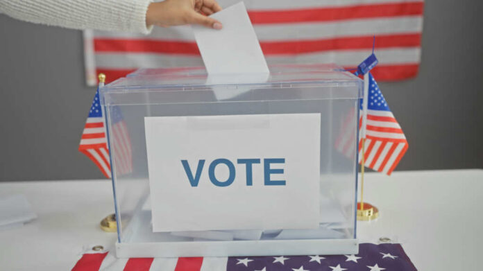 Hand placing ballot in box with American flags