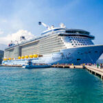 Cruise ship docked with people walking nearby