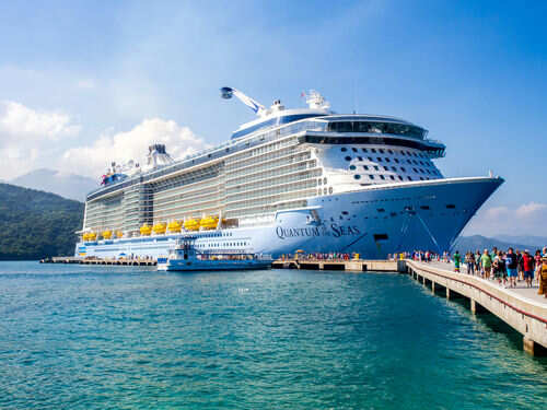 Cruise ship docked with people walking nearby