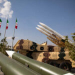 Ceasefire Clock Ticks: US-Iran Showdown Military missiles displayed outdoors with Iranian flags in the background