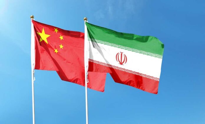 Flags of China and Iran waving against a blue sky