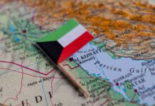 Small flag of Kuwait placed on a map of the Middle East