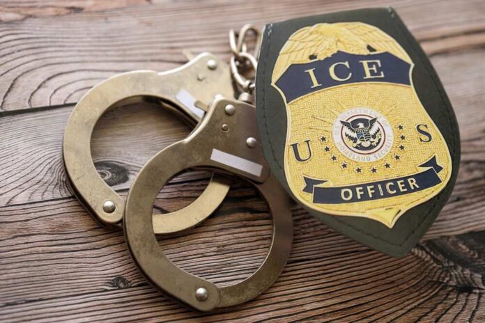 Handcuffs and a police badge on a wooden surface