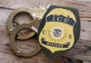 ICE Operation Fiasco: Child Left Alone in Car ICE officer badge next to handcuffs on a wooden surface