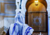 A person wearing a tallit in a synagogue during prayer