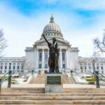 Capitol building with statue in foreground.
